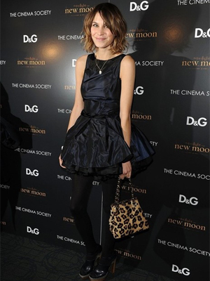 Alexa Chung wearing a sleeveless black dress with opaque tights